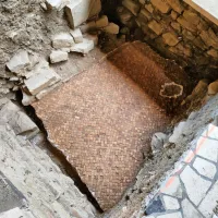  Pogled na konservirani mozaik iz opečnih kock, ki merijo od 2 do 4 centimetre. 