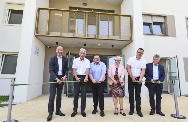 Trak so ob odprtju dveh blokov  prerezali (z leve) Tomaš Boček, 
vice guverner CEB, Črtomir Remec, direktor Stanovanjskega 
sklada RS, Simon Maljevac, minister za solidarno prihodnost,   
Jerneja Jug Jerše, vodja predstavništva Evropske komisije v 
Sloveniji, Aleš Bržan, koprski župan, in Zlatko Kuštra, direktor JSS 
MOK.  