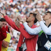 Luka Potočnik (desno)  in ostali tekmovalci preučujejo plezalne probleme na plezalni steni. 