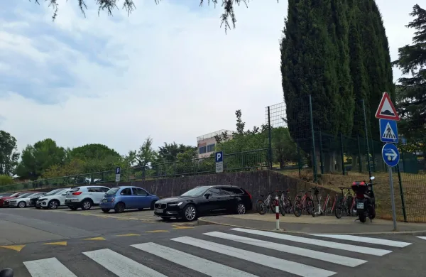 Parkiranje v Veluščkovi ulici je brezplačno in dopoldan, ko že poteka šolski pouk, je parkirišče običajno 
prazno.  


