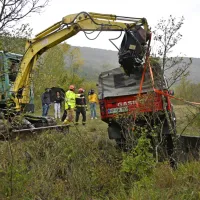 Land rover defenderja so gasilci s kopačem dvignili iz jarka 
potoka, da so ga lahko povlekli na travnik.