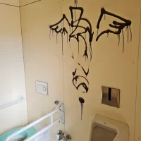 Grafit na steni    poškodovanih  javnih  stranišč.