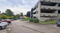 Lokacija ob grmovju pri parkirni hiši v Prisojah, kjer je krajanka 
kljub dovolilnici za parkiranje prejela globo.
