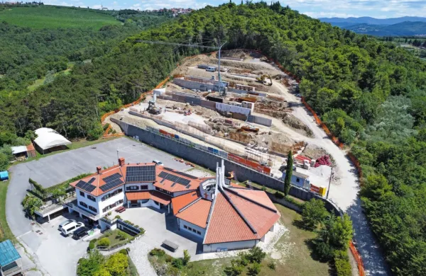 Podporni zid za župnijsko cerkvijo je sedaj v smeri proti gozdu 
daljši za 12 metrov - tega podaljška gradbeno dovoljenje ne 
omenja, zato pa projekt za izvedbo. Ali bi teh nekaj podaljšanih 
metrov gradbeno dovoljenje moralo omenjati ali ne, si sodelujoči 
niso enotni. 