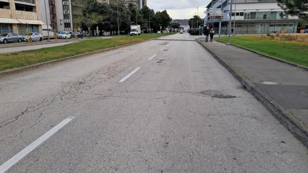 Nespodobno cestišče in neurejen pločnik na robu mesta