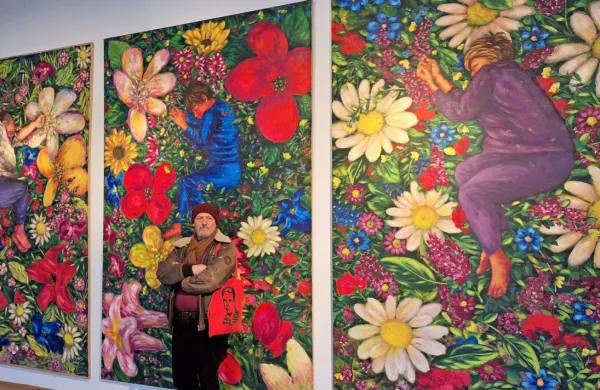 Gani Llalloshi na razstavi Nostalgija pred triptihom, na katerem je 
upodobil ženo, hčerko in sebe.