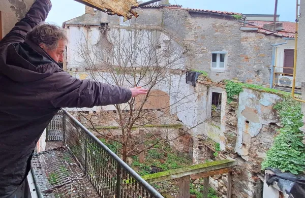 Alen Pušpan kaže, do kam naj bi segala  terasa novega objekta. 
“Vsega pol metra stran od mojega balkona. To je nesprejemljivo!”