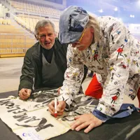 Tulio Furlanič se podpisuje na originalen plakat iz 60. let, ki ga je 
na koncert v Bonifiko prinesel zvesti oboževalec Kameleonov.    