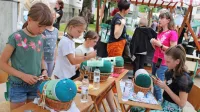 Učenke čipkarske šole ob učenju razstavljajo in pomagajo na prireditvah (fotografija je z lanskega Festivala 
idrijske čipke).
