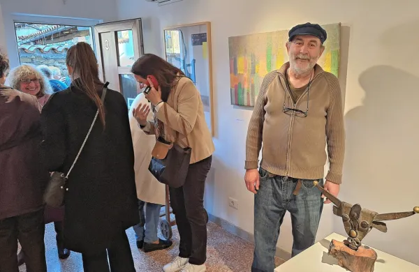 Edo Zanco na razstavi ob kipu boškarina, v ozadju ena izmed slik, levo nasmejana  gostiteljica Graziella Ponis 
Sodnikar

