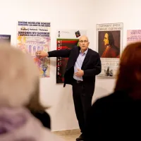  Tomi Brezovec med  razstavljenimi starimi turističnimi plakati.     