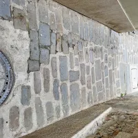 Primer interventnega posega v kanalizacijsko omrežje, stanje pred 
posegom, po posegu in stanje po prvem neurju. Primer tlakovcev, 
položenih v peščeno podlago na tradicionalen način, medtem ko 
je levi del ulice ostal fugiran s cementnimi fugami, kar narekuje 
razmike med tlakovci na območju posega, zato stičenje kljub 
dodajanju gradiva ni optimalno, rege med tlakovci ostajajo 
preširoke, in posledično na ulicah z naklonom pri večjem nalivu 
tlakovce odnese