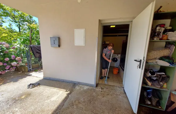 Jolica Vrtovec je dopoldne še čistila  prostore, ki jih je ponoči zalila 
deroča in blatna voda.  