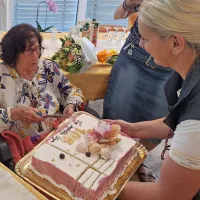 Olga je pogumno zarezala v torto, ki so ji jo podarili v domu v 
Olmu.