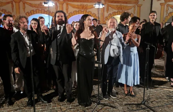 Dirigent George Pehlivanian (desno med pevkama) je bil, kljub 
skrčenemu  ansamblu, upravičeno zadovoljen s koncertno izvedbo 
opere Don Giovani na idrijskem gradu.