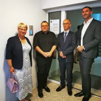 Odprtja sta se poleg ministra za solidarno prihodnost Simona 
Maljevca in župana občine Tolmin Alena Červa udeležila tudi vodja 
predstavništva Evropske komisije v Sloveniji Jerneja Jug Jerše in 
direktor Urada RS za okrevanje in odpornost Josip Mihalic.