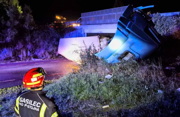Prikolica je pristala na cesti pod avtocesto, kabina pa se je zarila v 
brežino.