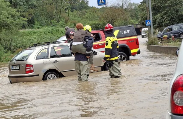 Voznika in sopotnico so gasilci rešili s poplavljenega vozišča.