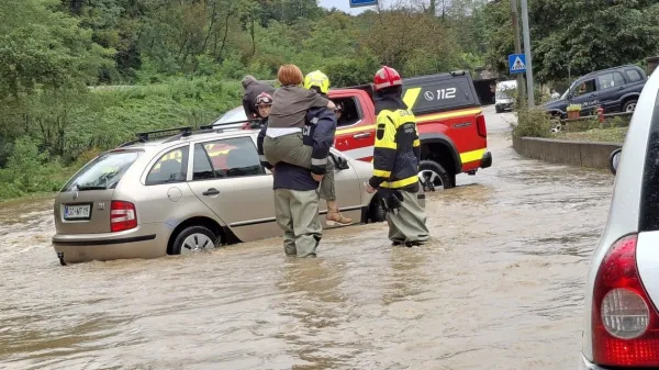 Voznika in sopotnico so gasilci rešili s poplavljenega vozišča.