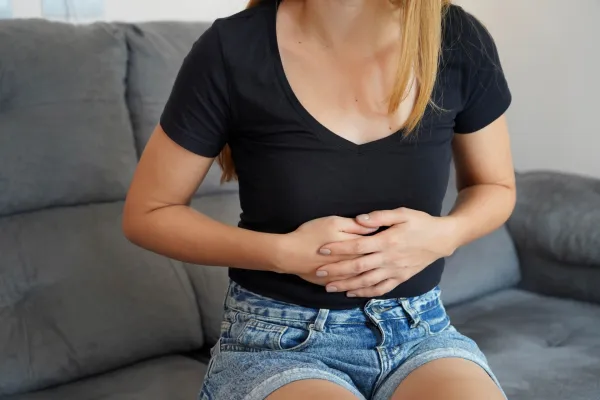 Digestive problems from poor diet. Young woman suffering from strong abdominal pain while sitting on sofa at home.,Image: 799492359, License: Royalty-free, Restrictions:, Model Release: no, Credit line: Sergio Monti/Panthermedia/Profimedia