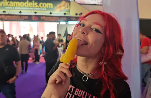 Dildo na glavi, lizalka v obliki penisa v ustih, predvsem pa veliko gole kože