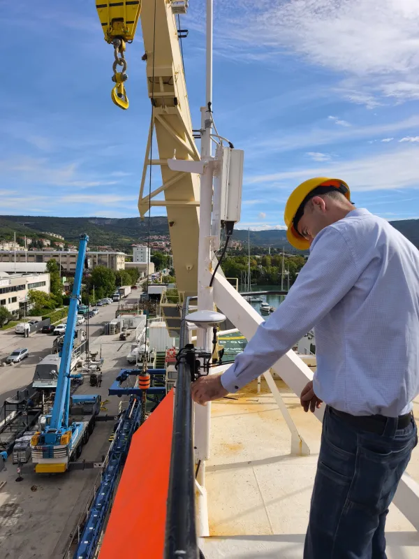 Pritrjevanje širokopasovne antene na ograjo ladje.