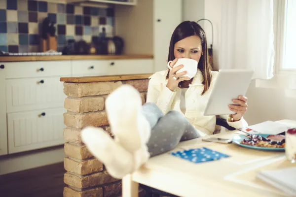 Beautiful young woman is having breakfast in the kitchen