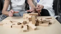 Dementia therapy in playful way, training fingers and fine motor skills, build wooden blocks into tower, playing Jenga. Senior woman 90 years old and doctor playing educational game in nursing home,Image: 998441883, License: Royalty-free, Restrictions:, Model Release: yes, Credit line: Yelizaveta Tomashevska/imageBROKER/Profimedia