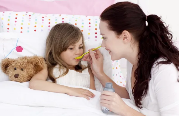 Little girl in bed taking syrup with her mother,Image: 138467204, License: Royalty-free, Restrictions:, Model Release: yes, Credit line: -/Wavebreak/Profimedia