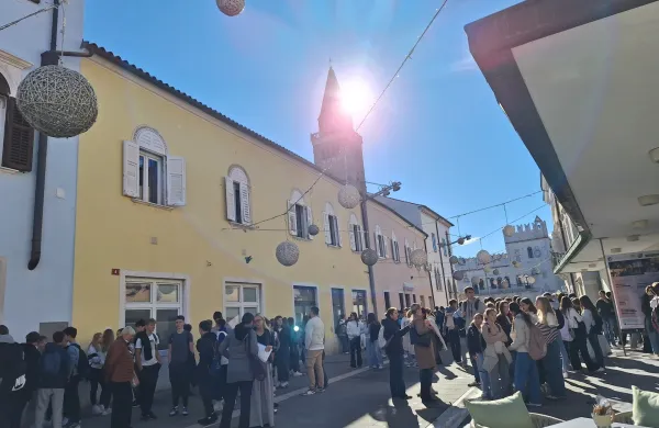 Pogled s terase Caff&egrave; Verde na polno Verdijevo ulico in s soncem obsijani Titov trg v Kopru 