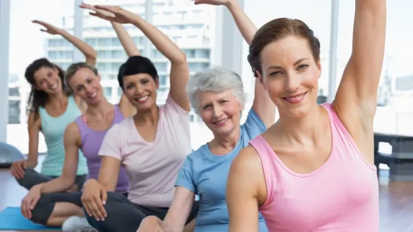 Portrait of a smiling trainer with women in row stretching hands at yoga class,Image: 187831793, License: Royalty-free, Restrictions:, Model Release: yes, Credit line: -/Wavebreak/Profimedia