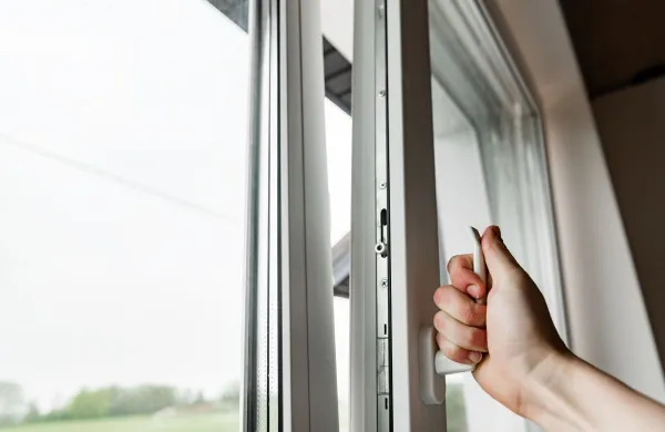 Hand opens white plastic window.