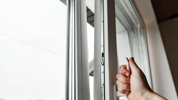 Hand opens white plastic window.