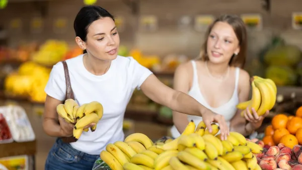Young and adult women buyers choosing bunch of fresh bananas in vegetable shop,Image: 1076978470, License: Royalty-free, Restrictions:, Model Release: no, Credit line: Iakov Filimonov/Alamy/Profimedia