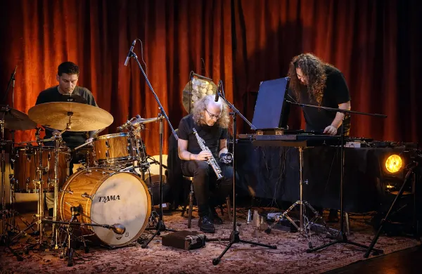 Trio sestavljajo Martin K&uuml;chen (saksofon), Gal Furlan (bobni) ter Andrej Kobal (skladatelj, zvočni oblikovalec žive elektronike)