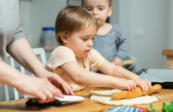 Toddler children help mom cook pizza. Family activity for development of fine motor skills. Child lays out pieces of bacon on pizza base dough.,Image: 1095582500, License: Royalty-free, Restrictions:, Model Release: no, Credit line: Iakov Filimonov/Alamy/Profimedia