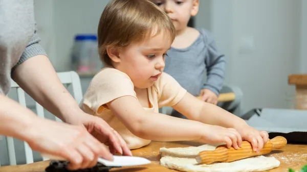 Toddler children help mom cook pizza. Family activity for development of fine motor skills. Child lays out pieces of bacon on pizza base dough.,Image: 1095582500, License: Royalty-free, Restrictions:, Model Release: no, Credit line: Iakov Filimonov/Alamy/Profimedia