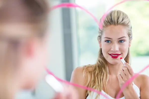 Woman with lipstick looking in the mirror in the bathroom,Image: 280467357, License: Royalty-free, Restrictions:, Model Release: yes, Credit line: -/Wavebreak/Profimedia